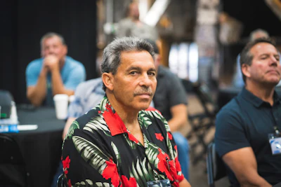 Middle-aged man in floral Hawaiian shirt at professional conference