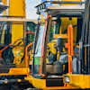Yellow industrial forklifts parked side by side with open cab doors