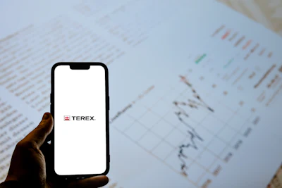 Terex corporate logo displayed on smartphone screen over business documents