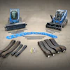 Two blue tracked machines with rubber tracks and attachments on concrete surface