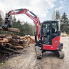 Red compact excavator moving timber logs at a forestry work site