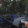 Construction site with blue excavation machinery and workers in orange safety vest