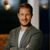 Professional man in gray blazer smiling with confident pose