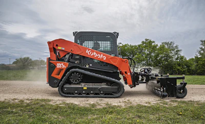 Orange Kubota SVL skid steer loader with attachment on dirt ground