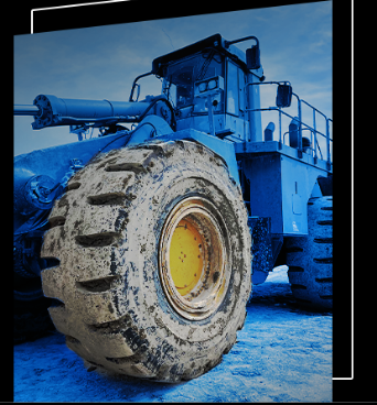 Large blue industrial wheel loader with muddy tire on blue background