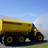 Large yellow industrial water truck by Philippi-Hagenbuch spraying water on pavement