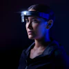 Person wearing high-tech headset against dark blue background