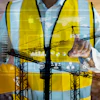 Construction worker analyzing digital data with cranes and technology interface