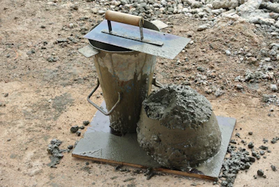 Construction tools with wet cement on concrete mixing surface