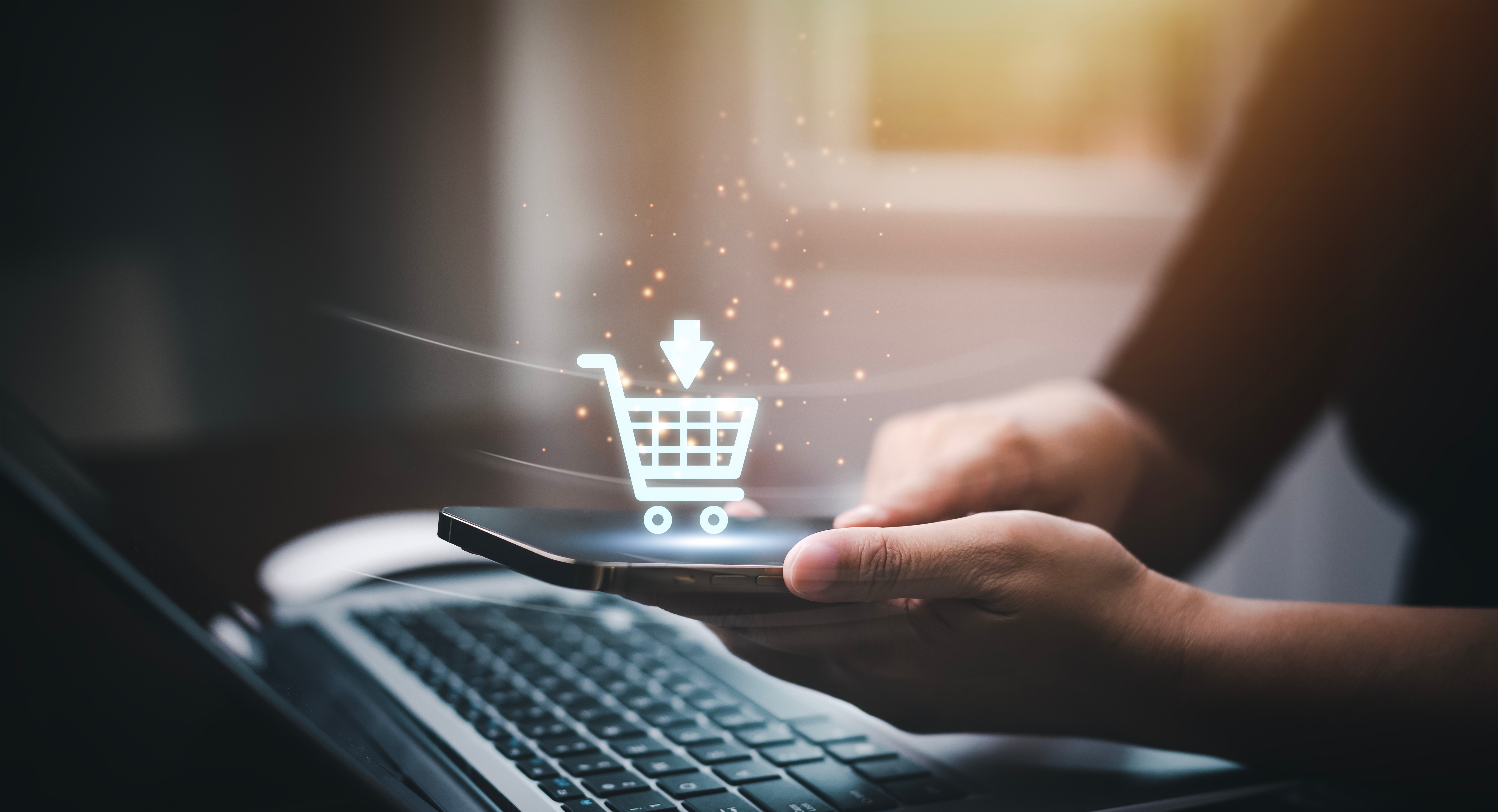 Hand holding smartphone with glowing digital shopping cart icon