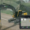 Excavator working on construction site with digital control display showing machine location