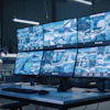Security control room with multiple monitors displaying surveillance camera feeds