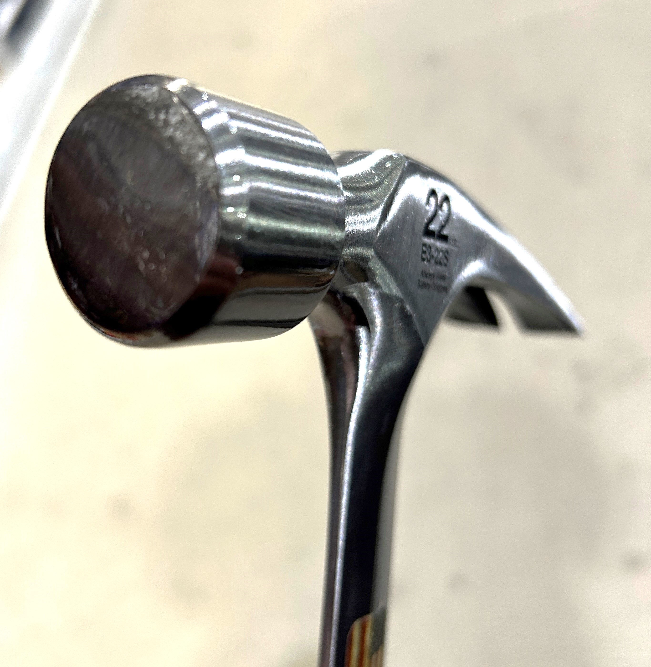 Silver hammer with curved handle and rounded head
