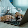 Professional working on laptop with digital invoice and document management icons