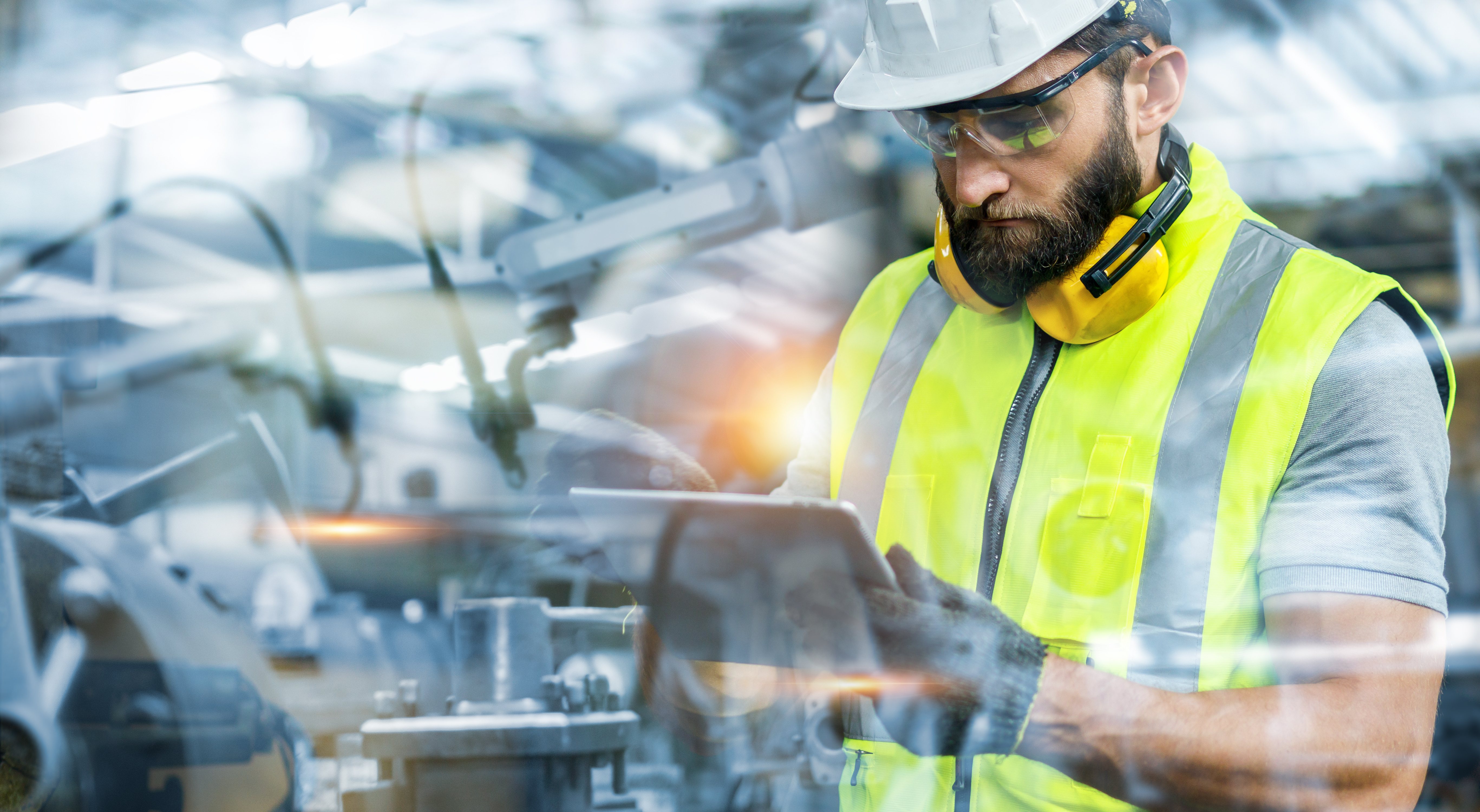 Construction worker in high-visibility vest and hard hat operating industrial machinery