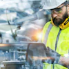Construction worker in high-visibility vest and hard hat operating industrial machinery