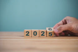 Hand flipping wooden block changing year from 2025 to 2026