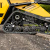 Yellow tracked industrial machine with complex wheel suspension on gravel surface