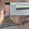 Concrete staircase with metal railings and black safety traction strips