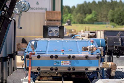 Blue industrial machinery with complex piping and connections in outdoor industrial setting