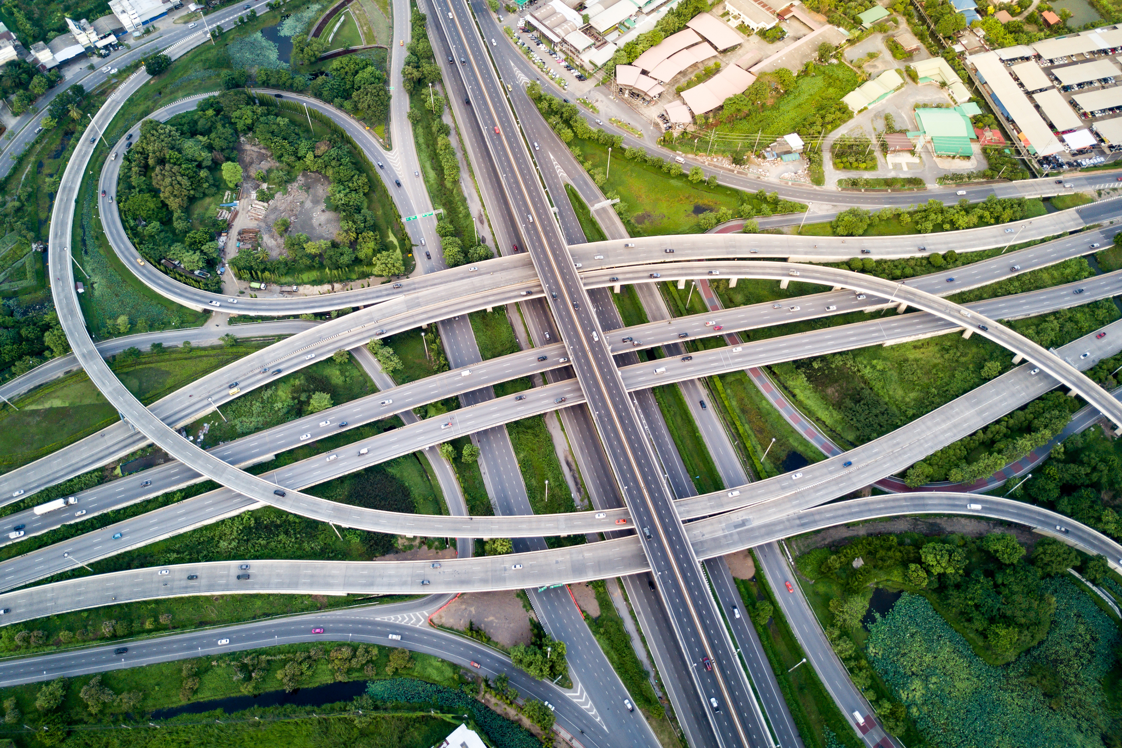Aerial view of complex multi-level highway interchange with curved roadways amid green landscape