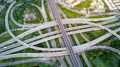 Aerial view of complex multi-level highway interchange with curved roadways amid green landscape