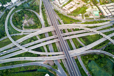 Aerial view of complex multi-level highway interchange with curved roadways amid green landscape