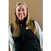 Smiling woman in white shirt and black Sunbelt Rentals vest against neutral background