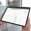 Tablet displaying business analytics dashboard with green and circular performance indicators