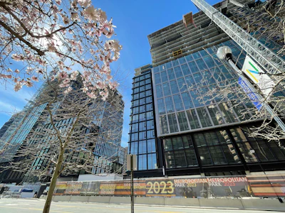 Modern glass office buildings with cherry blossoms under clear blue sky