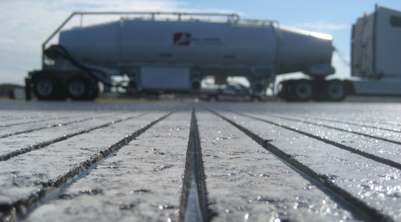 Industrial tanker truck on concrete surface with frost or moisture