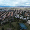 Aerial view of suburban neighborhood with curved streets and mountain range in distance