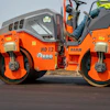 Orange Hamm road roller compacting asphalt on a construction site