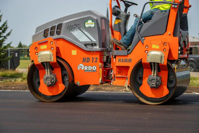 Orange Hamm road roller compacting asphalt on a construction site