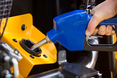 Blue fuel nozzle connecting to yellow industrial equipment