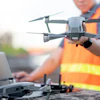 Construction worker in safety vest preparing drone for aerial survey