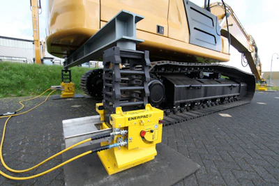 Yellow hydraulic lifting equipment mounted beneath heavy construction excavator