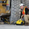 Construction worker using yellow Enerpac hydraulic equipment near industrial machinery