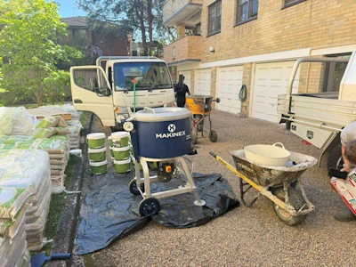 Construction site with Makinex equipment, truck, and building materials