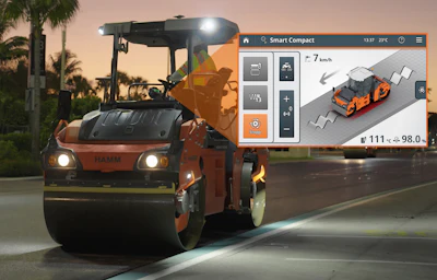 Orange Hamm road roller compacting pavement at dusk with digital control interface