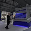 Industrial exhibition booth with blue-lit machinery and display screen