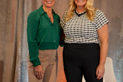 Two smiling blonde women in professional business attire standing together