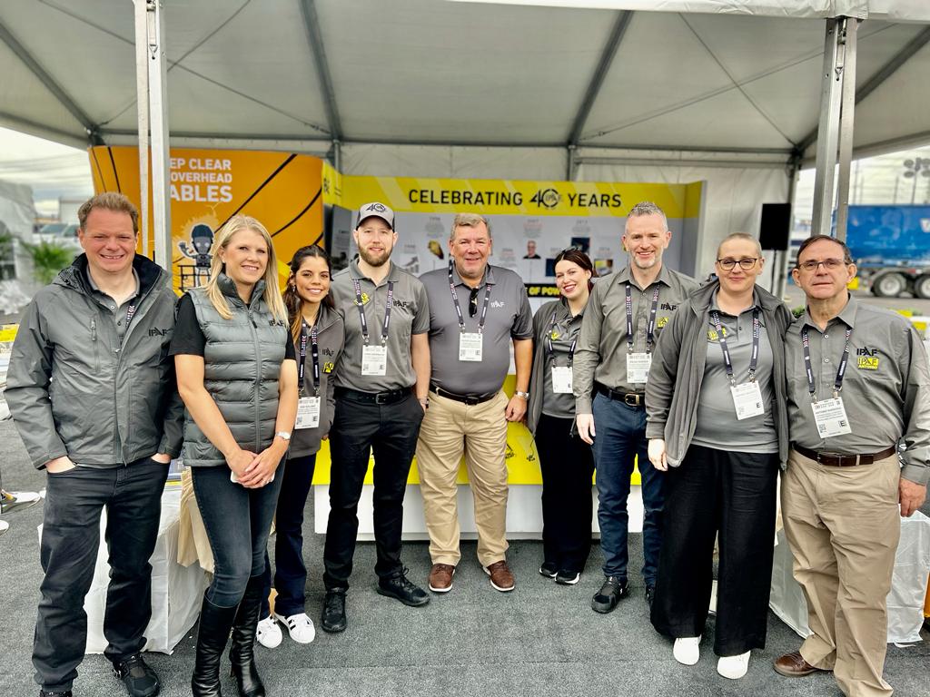 Team of eight professionals in gray uniforms at corporate event marking 40-year milestone