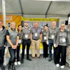 Team of eight professionals in gray uniforms at corporate event marking 40-year milestone