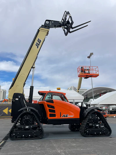 Orange JLG tracked telehandler with extended lifting arm at outdoor industrial event