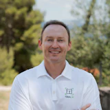 Smiling professional in white Togal.AI polo shirt standing outdoors