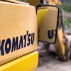 Yellow Komatsu construction machinery close-up with industrial background