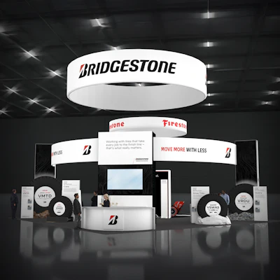 Bridgestone trade show booth with illuminated signage, featuring 'Move More with Less' tagline and multiple product displays