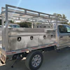 Silver pickup truck with aluminum utility bed and overhead rack in parking lot