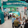 Trade show booth showcasing fleet management technology with attendees and displays